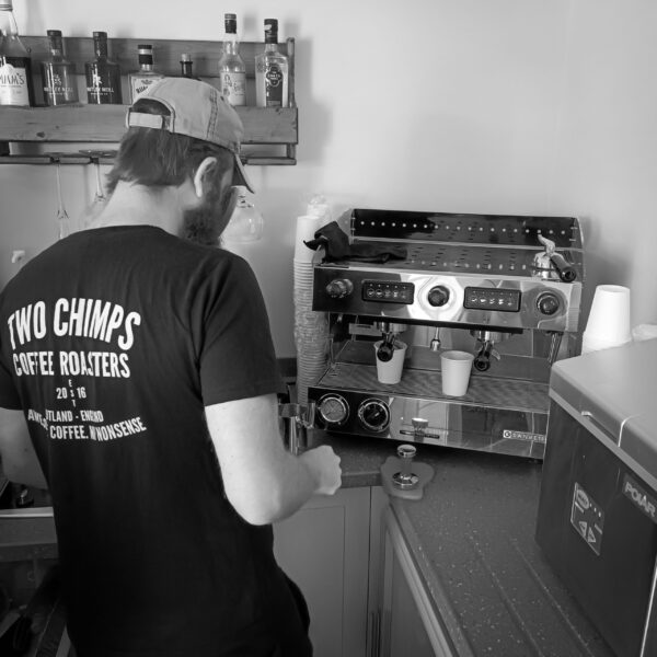 back of a tshirt showing a two chimps barista dialling coffee machine