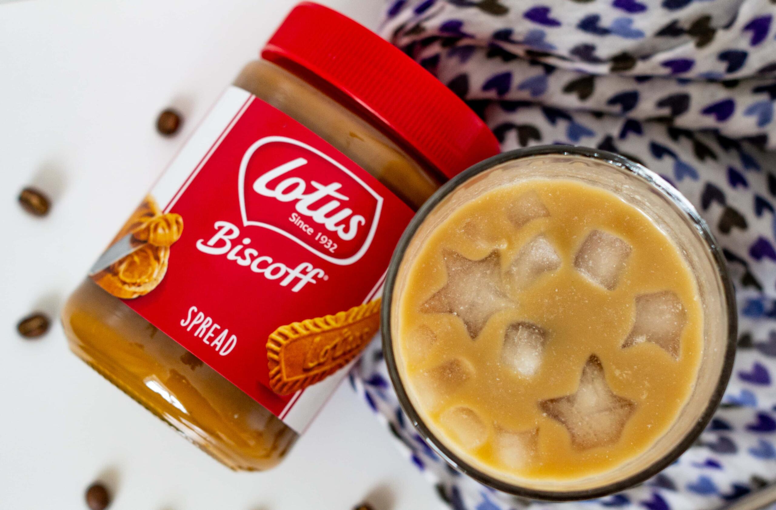 Iced latte from above with jar of Biscoff spread on blue cloth