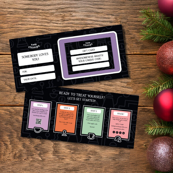 Two chimps gift voucher with baubles on a table