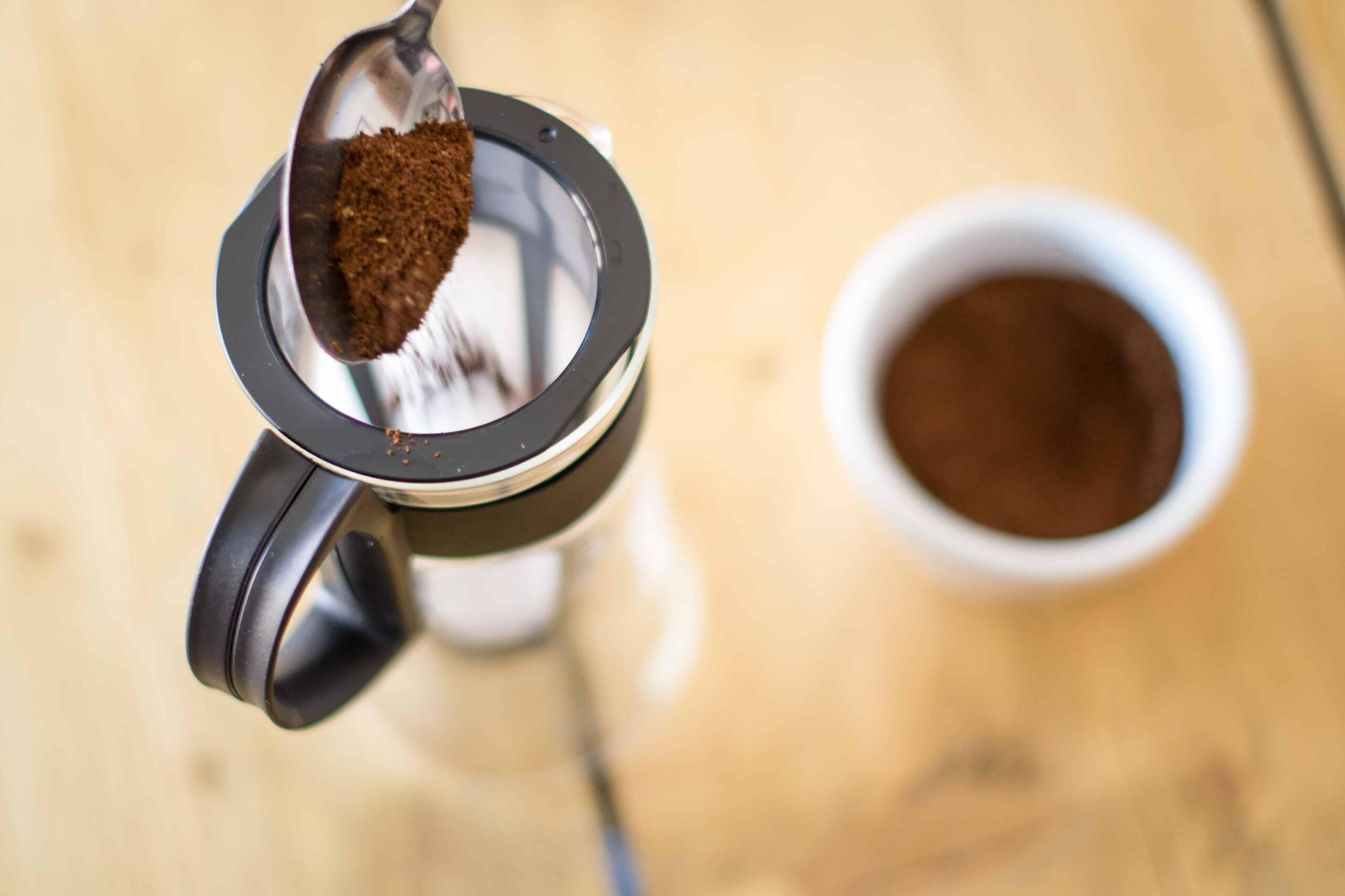 Coffee grounds being poured into cold brew coffee pot