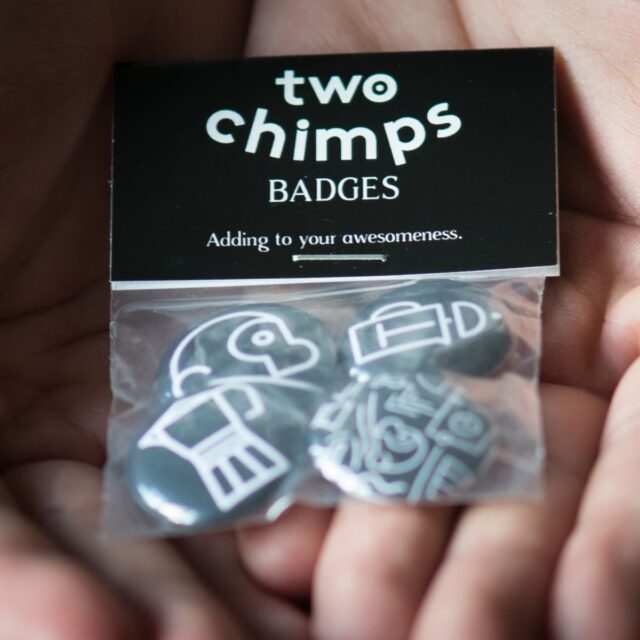 hands holding a badge pack by two chimps coffee