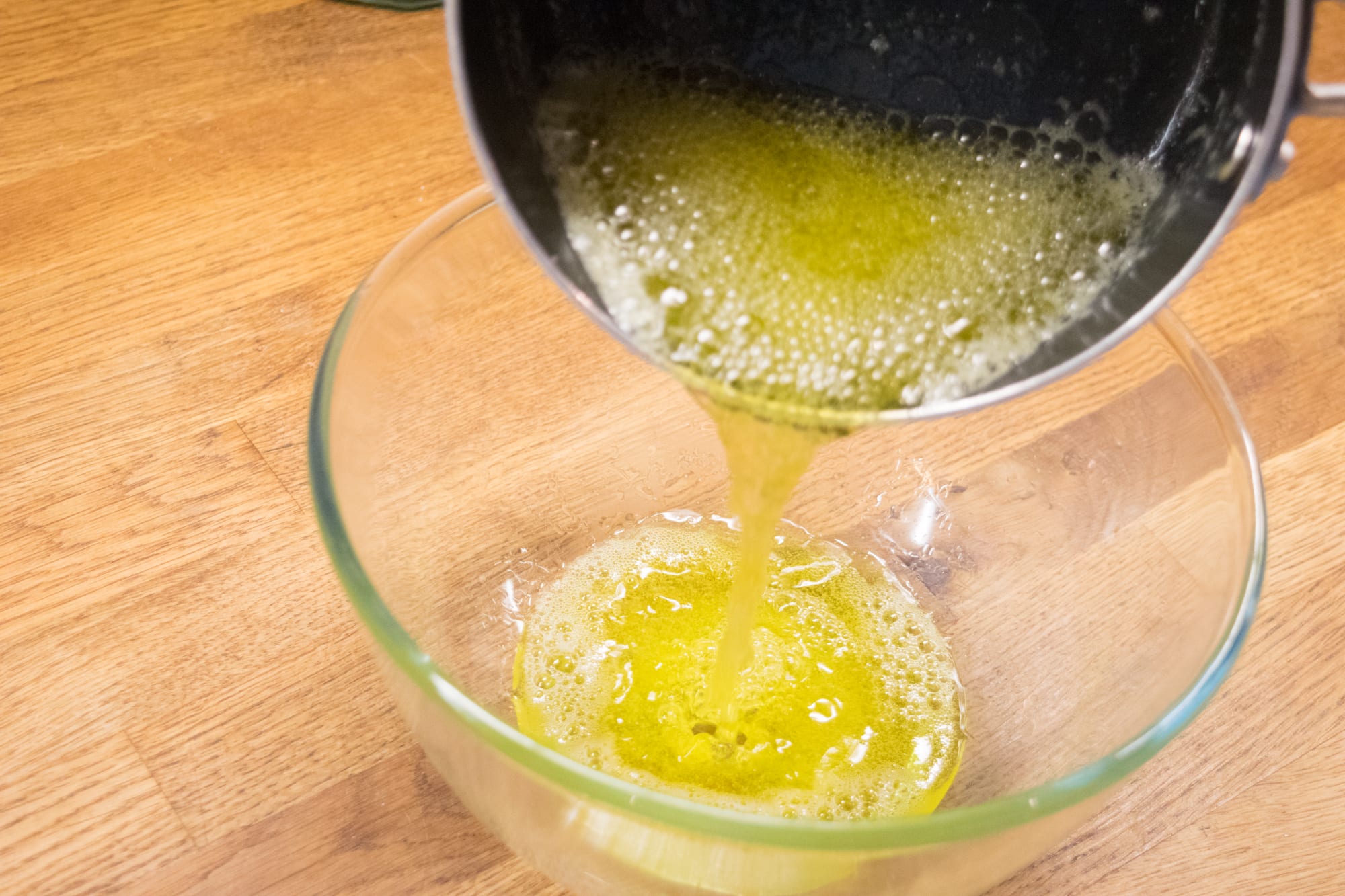 pouring melted butter into a glass bowl