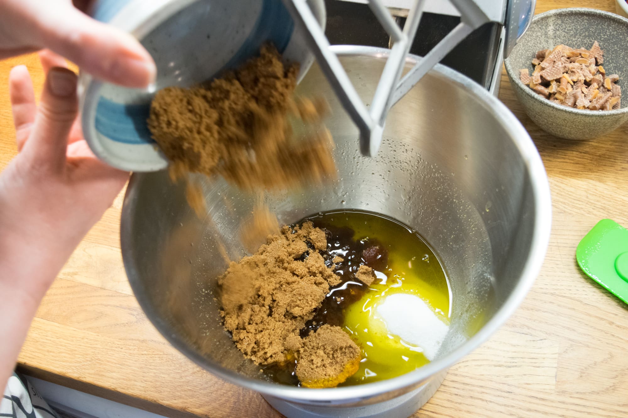 pouring sugar into a bowl of melted butter