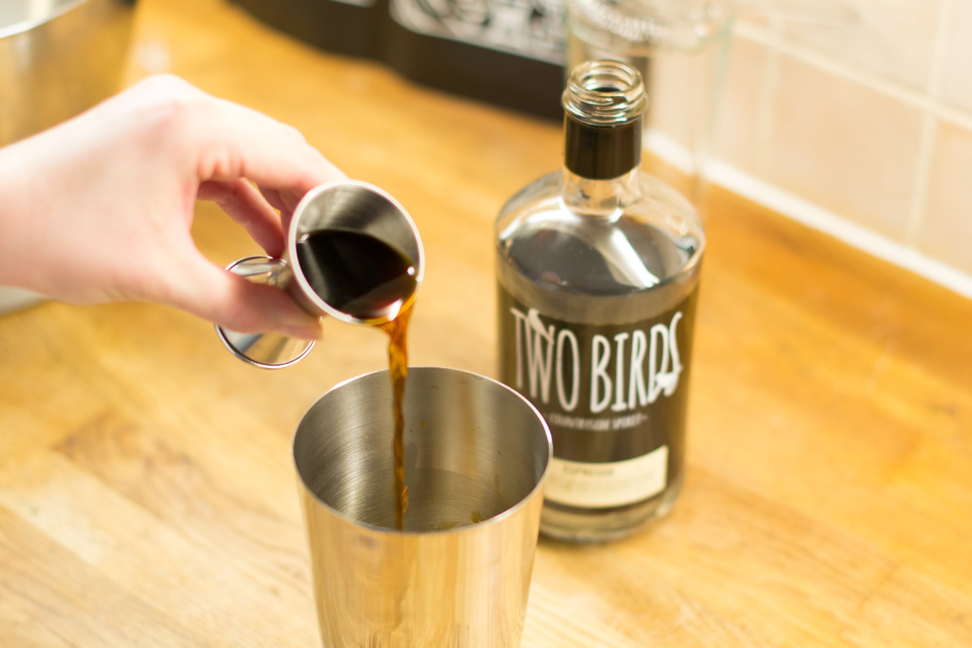Pouring espresso liqueur into cocktail shaker