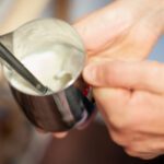 steaming milk using a steam wand on an espresso machine