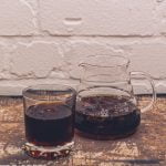 A carafe and glass of iced coffee