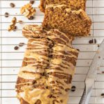 coffee and walnut loaf cake sliced on a wire cooling rack with a silver knife