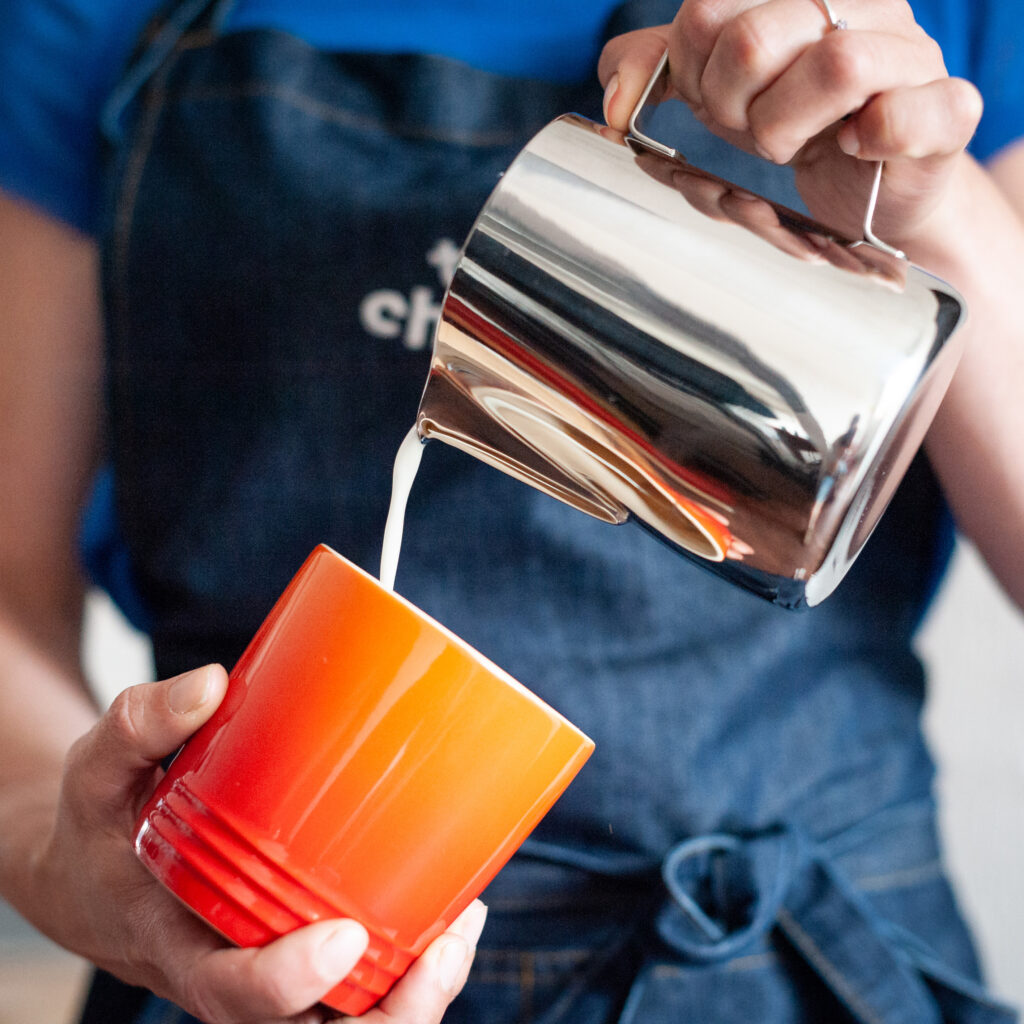 Pouring milk into coffee mug