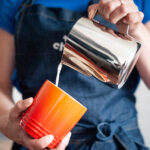 Pouring milk into coffee mug