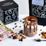 Jar with mocha oats besides Two Chimps coffee tin and pouch and Whitworths dried fruit packets