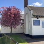 Ashby Arms pub exterior beside dark purple tree