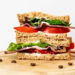 BLT sandwich on chopping board with coffee beans