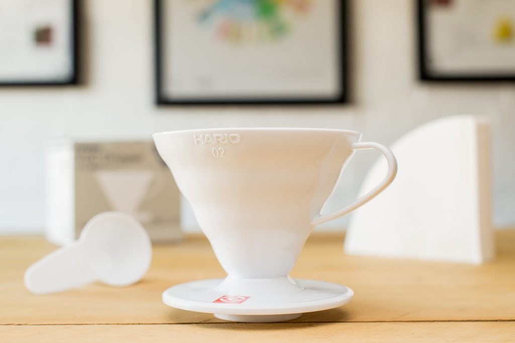 v60 dripper on a table with scoop and filter papers
