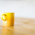 a yellow mug on a coffee table