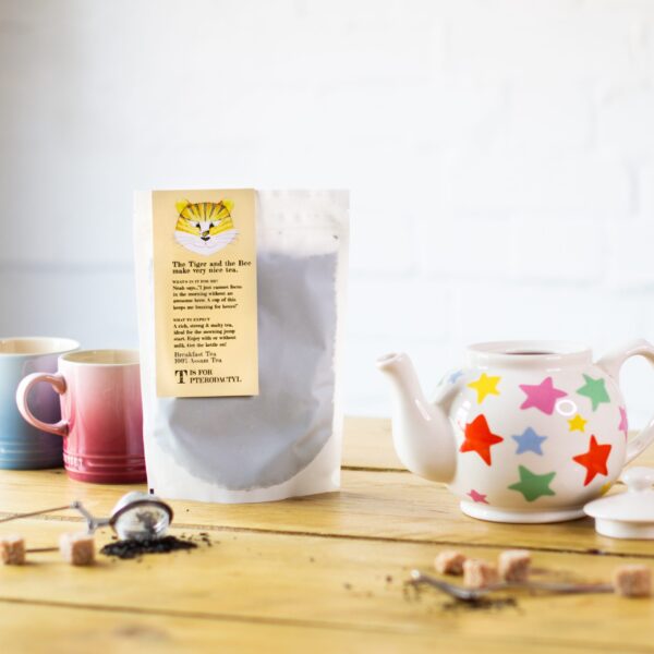 bag of breakfast tea with teapot, sugar lumps and cups