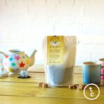 Two Chimps loose leaf english breakfast tea beside blue mug, teapot and sugar cubes