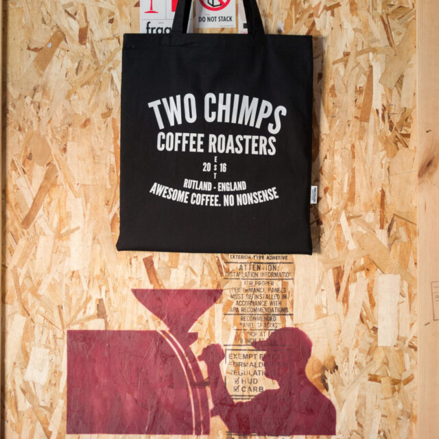 two chimps tote bag on a wooden crate