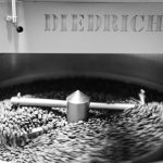 black and white image of coffee beans being spun around in the coffee diedrich roasting machine