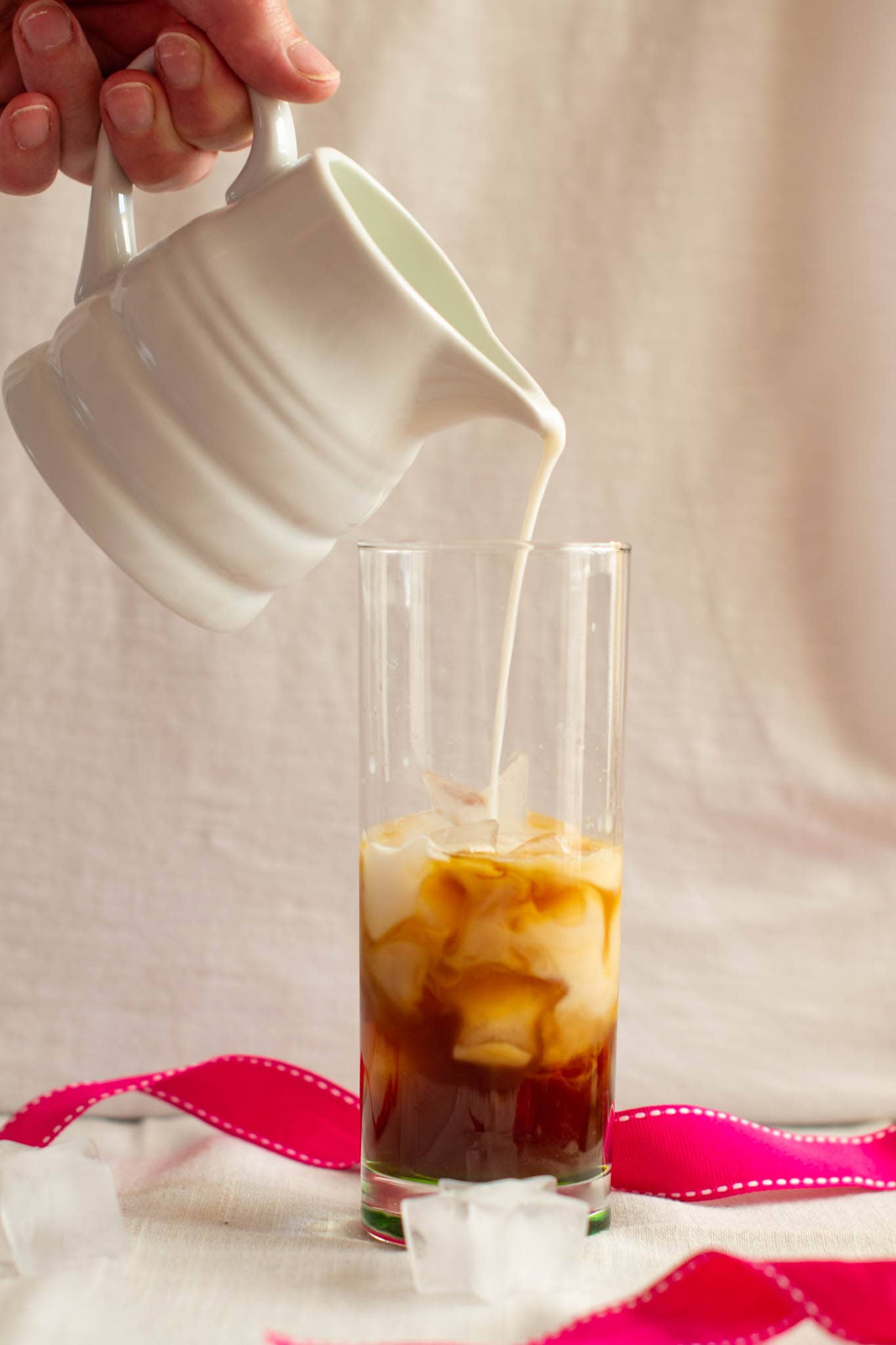 Pouring milk into iced latte