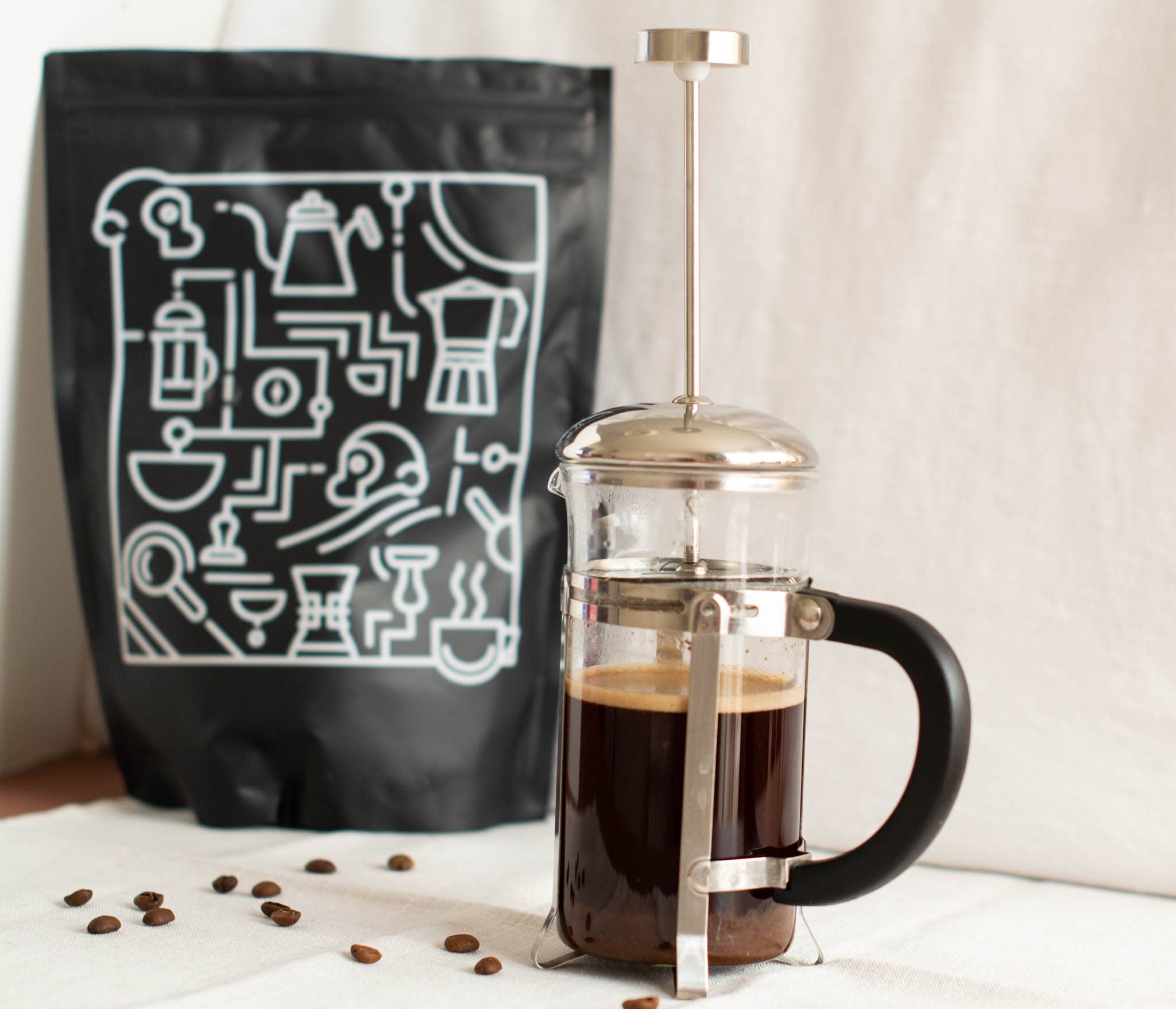 Small French press beside bag of Two Chimps coffee