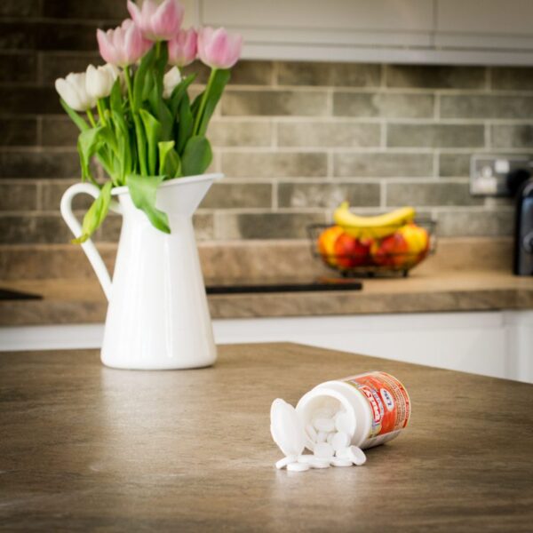 open tub of puly cleaning tablets on kitchen worktop