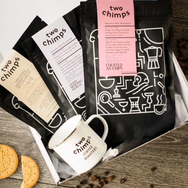 birds eye view of three bags of two chimps coffee with a two chimps mug in a white gift box