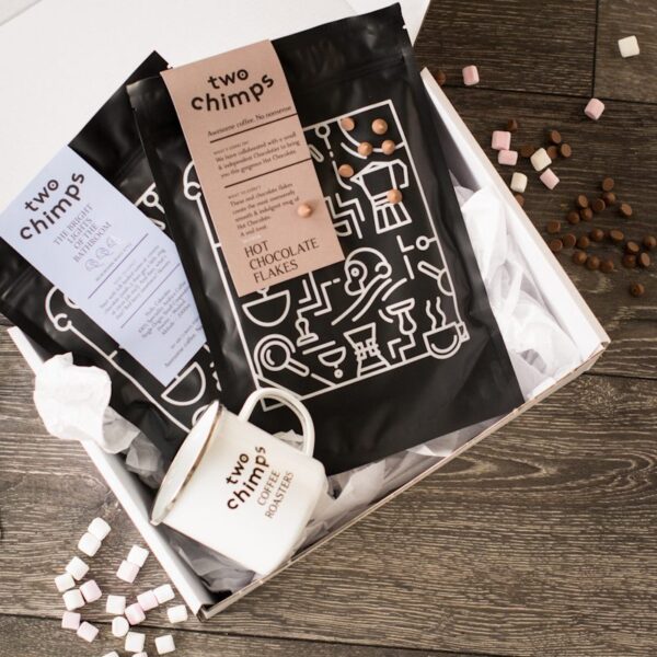 birds eye view of two chimps coffee with a bag of hot chocolate flakes and mug in a white gift box