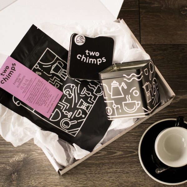 birds eye view of decaf coffee with a two chimps magnet and tin in a white gift box