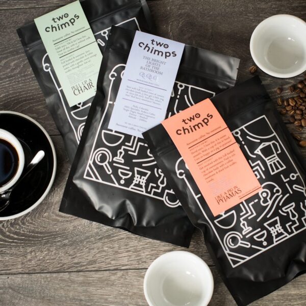 close up of three bags of two chimps coffee on wooden table