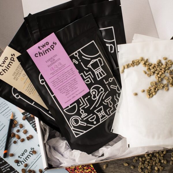 two bags of roasted and two bags of unroasted two chimps coffee in a white gift box