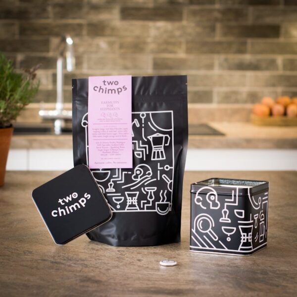 one bag of two chimps decaf coffee with a two chimps tin and magnet on a kitchen worktop
