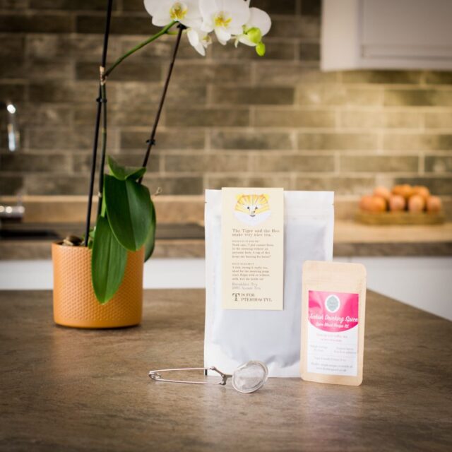 loose leaf breakfast tea with a tea infuser and spice pouch on a kitchen worktop