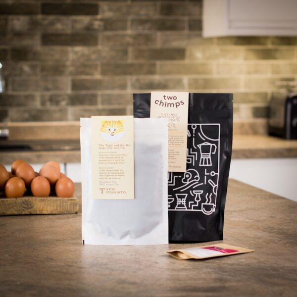 a bag of two chimps coffee with a bag of loose leaf breakfast tea and a spice pouch on a kitchen worktop