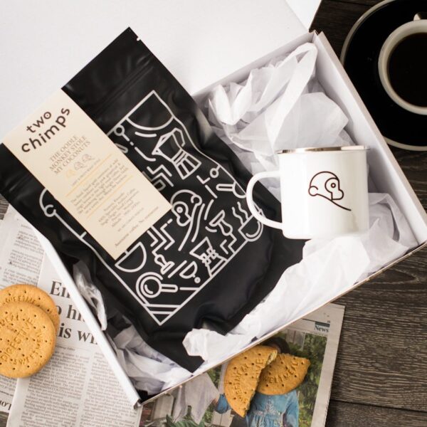 close up of two chimps coffee bag and mug in white gift box