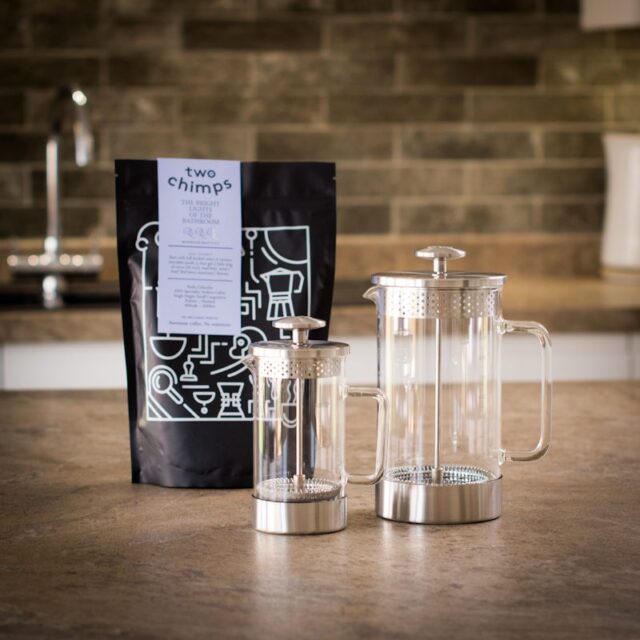 two barista & co cafetieres in different sizes with a bag of two chimps coffee on a kitchen worktop