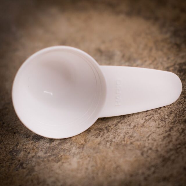 White plastic v60 measuring spoon on worktop