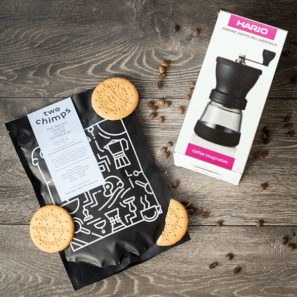 Hand grinder with bag of coffee on table